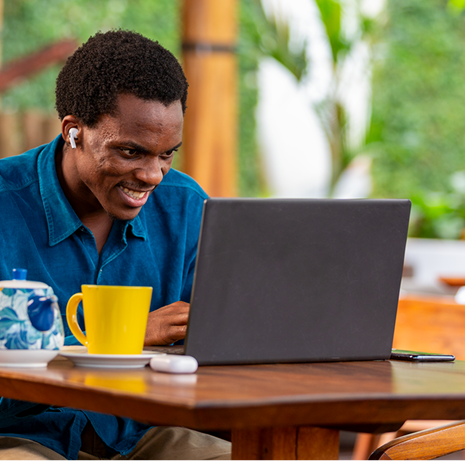 Man in Blue Shirt Looking at Laptop and Smiling 2