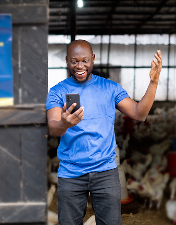 Man in blue t shirt looking at his phone and smiling
